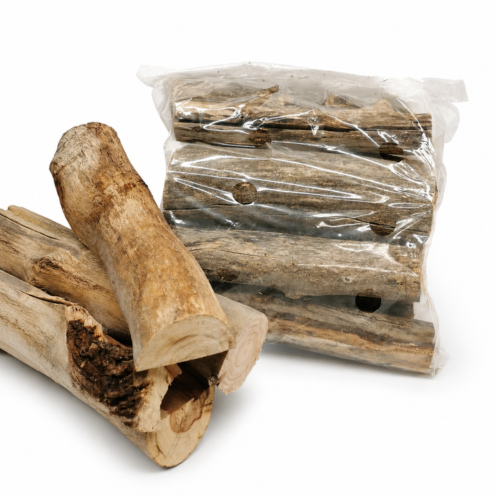 Wooden logs with a clear plastic bag containing more logs on a white background